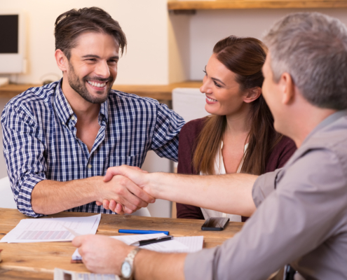 Young couple shaking hands with debt relief consultant